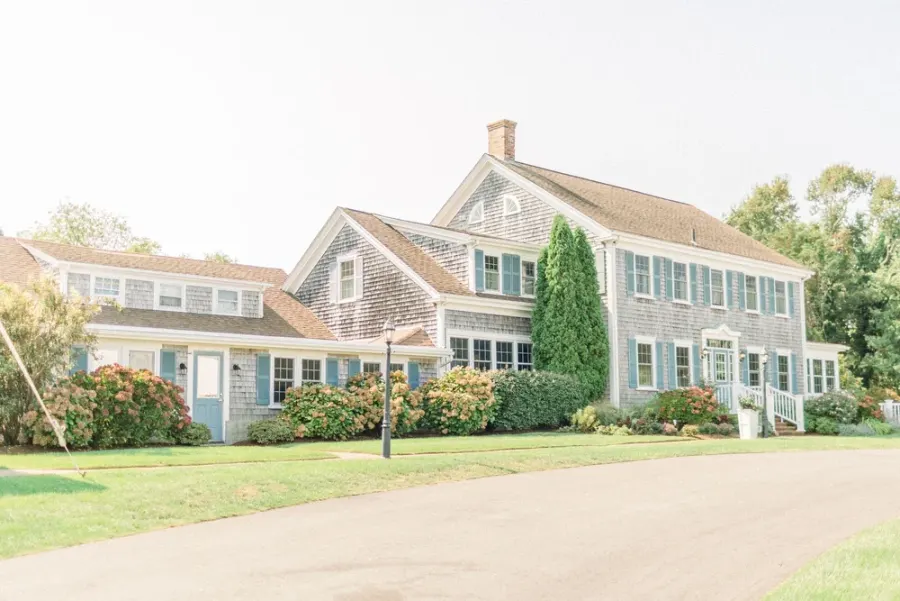 The shingled front of The Dennis Inn on a summer day